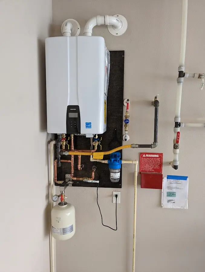 Professional plumber installing copper piping in a Cambria home